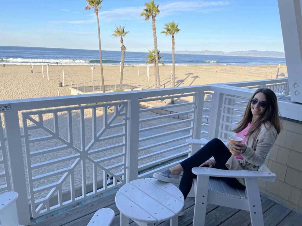 woman sitting on balcony by the beach, beach house hotel