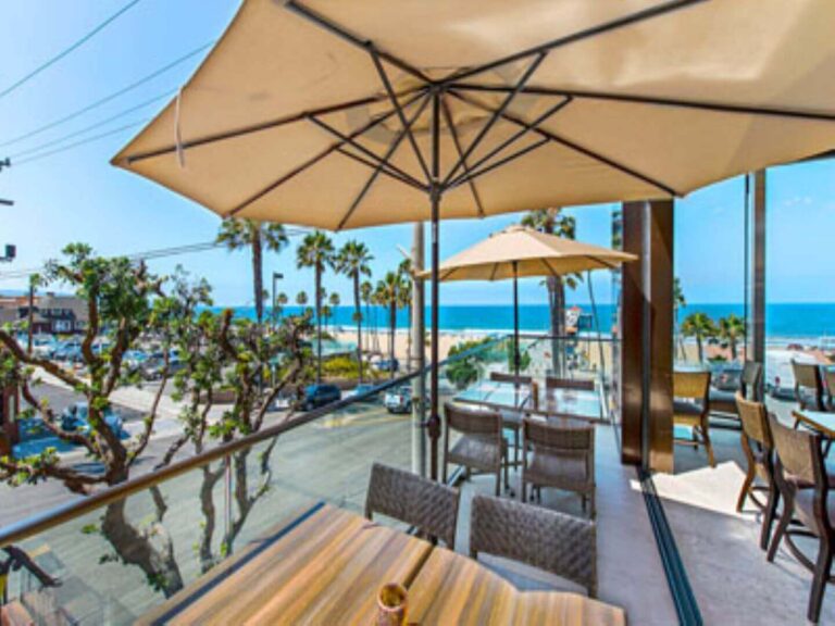 Strand House with an ocean view and tables with umbrellas