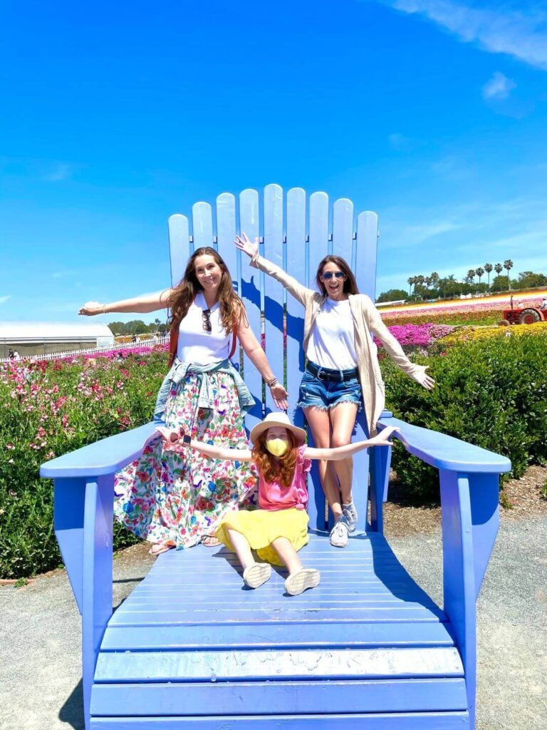 Three people on a large chair at the Carlsbad Flower Fields