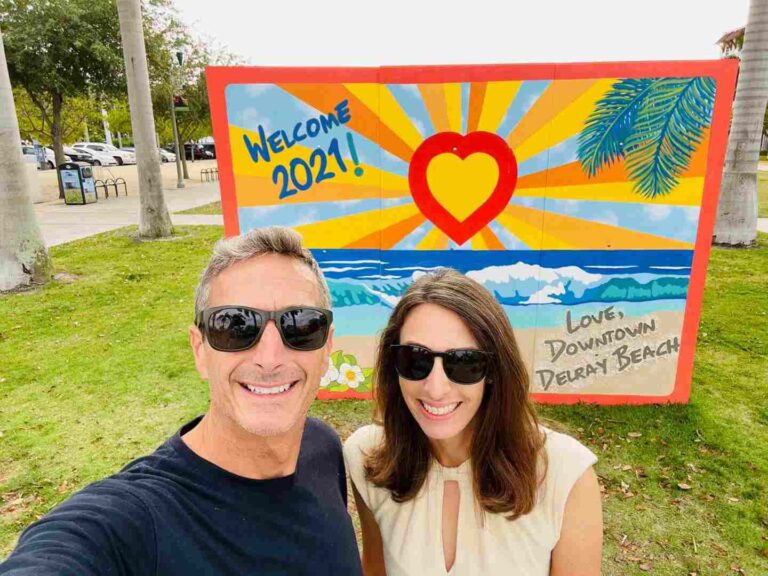 Welcome to Delray Beach sign with a couple