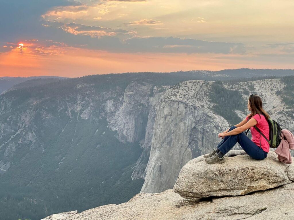 Woman admiring the sunset from Taft Point in Yosemite National Park - things to do in Yosemite National Park at Night