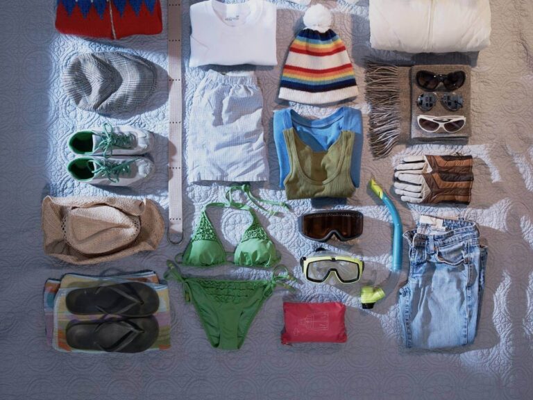 Clothes laid out on a bed to be packed, Tips for packing a suitcase like a professional