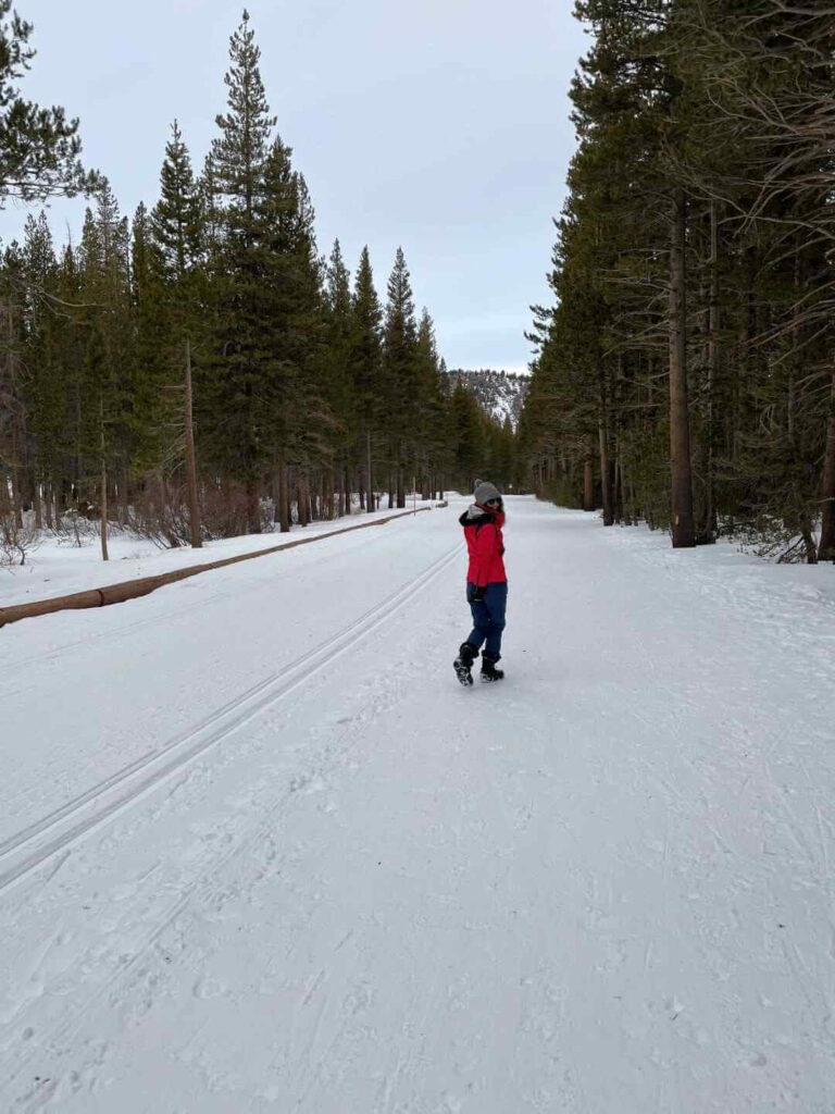 Woman walking on a groomed snowy trail in Mammoth Lakes in the winter