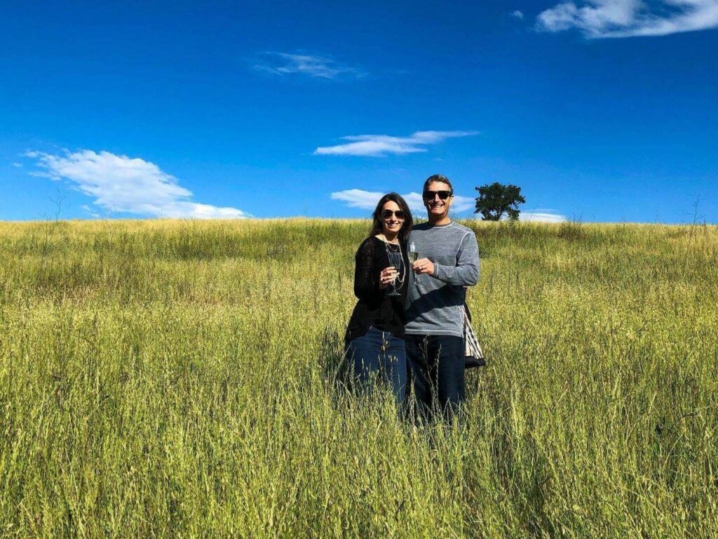 Couple in a field near Los Olivos holding champagne glasses