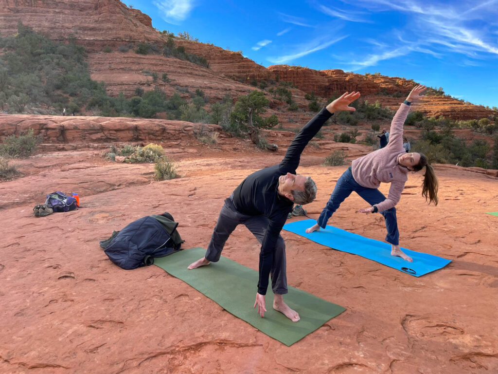 Couple doing yoga at Catherdral Rocks