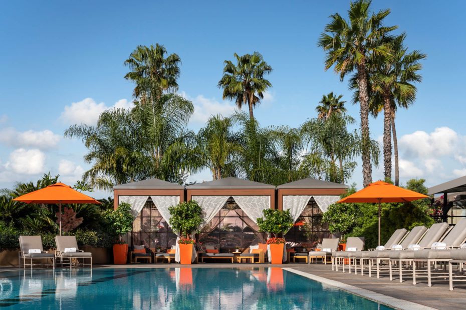 Four Seasons Hotel Los Angeles at Beverly Hills Pool with poolside cabanas, lounge chairs, orange umbrellas and palm trees