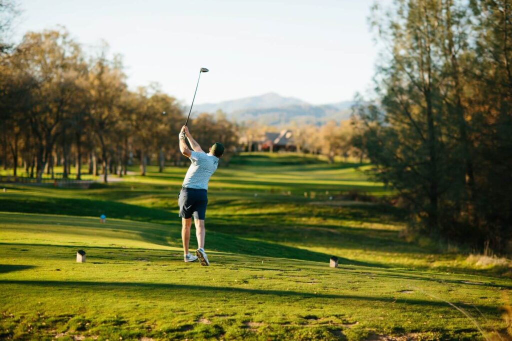 A man hitting a golf ball on a golf course in Redding