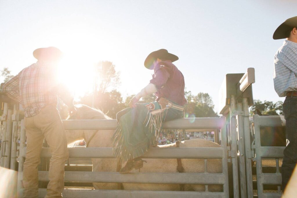 Man at a rodeo getting ready to ride his hourse