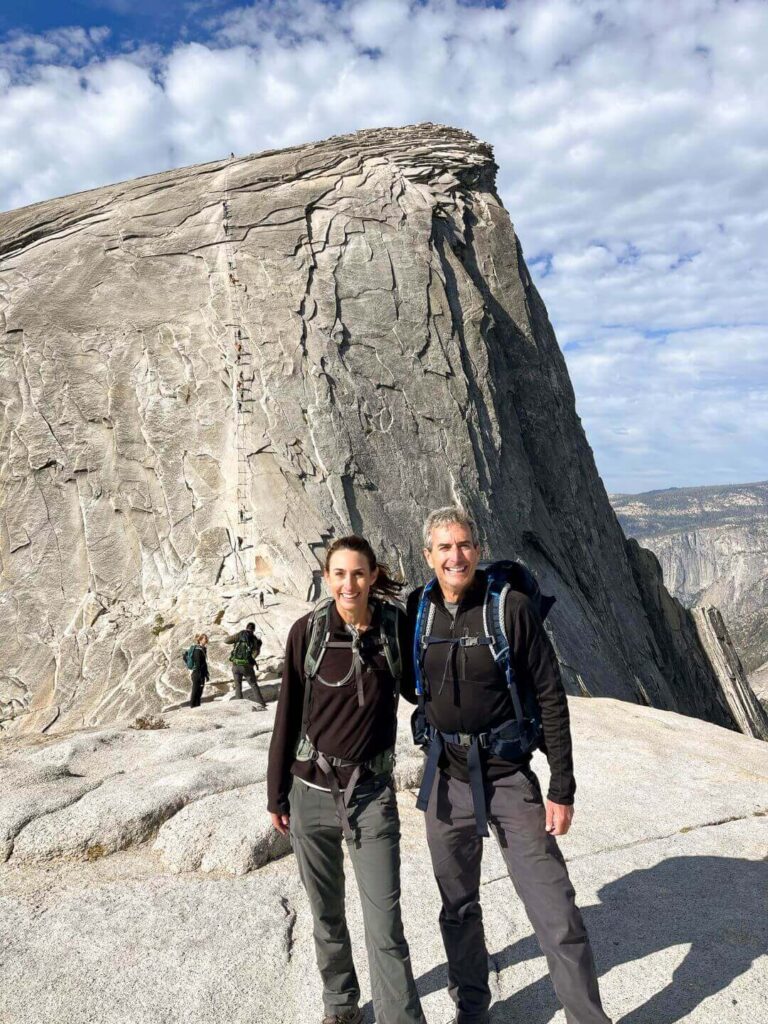 Couple standing in front of the Half Dome cables