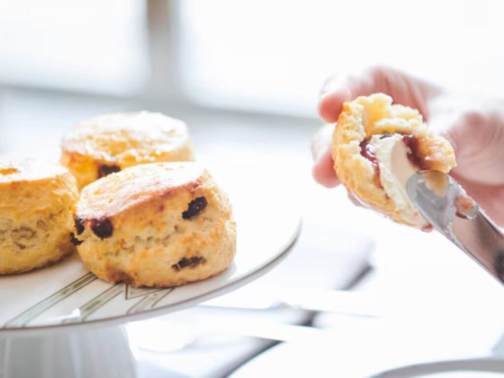 Person adding butter to scone during the afternoon tea at The St. Regis Hong Kong 