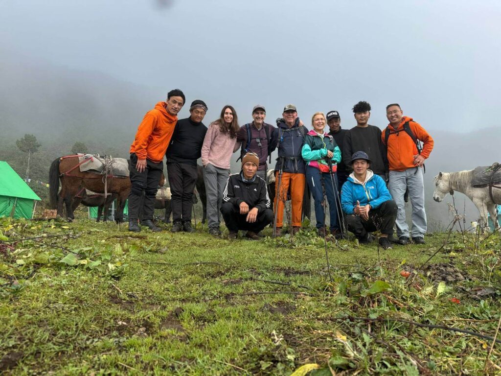 Bhutan Druk Trek Group Picture of 11 people, horses, and campsite