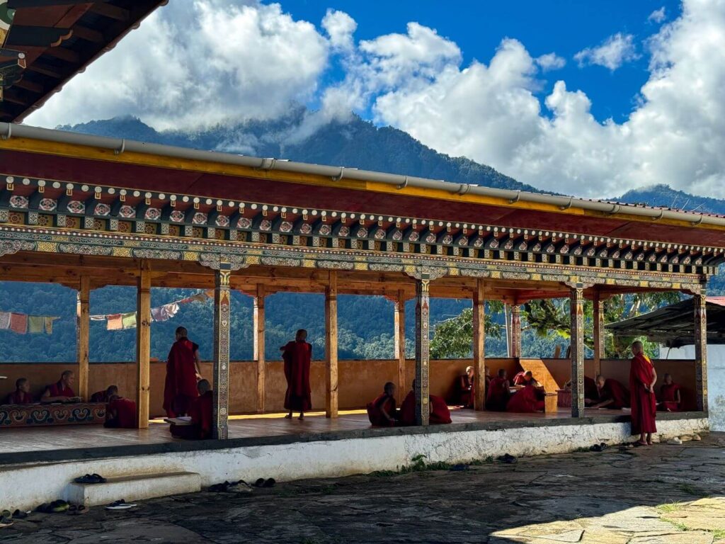 Monks at a monestary with mountains in the background