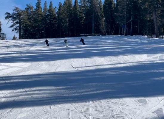 Three people in unison skiing June Mountain