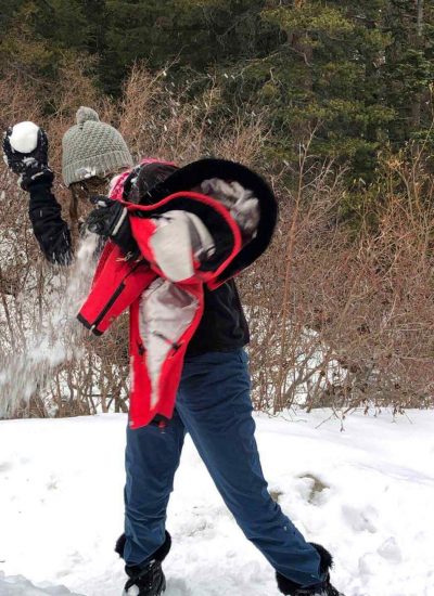 Woman getting hit with a snowball in Mammoth Lakes in the winter